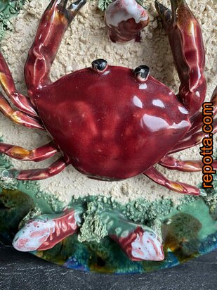  majolica bord met zeekrab tussen zand en schelpen 
