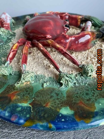  majolica bord met zeekrab tussen zand en schelpen 